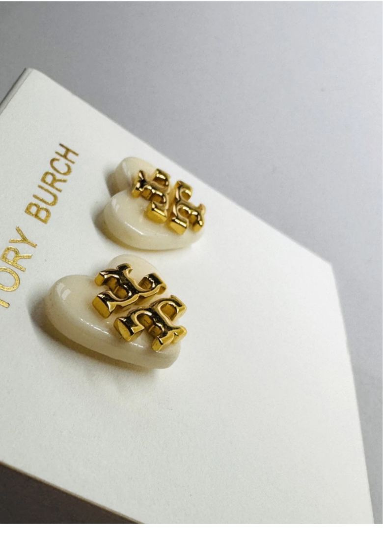 Aretes marca Tory Burch sobre corazón blanco