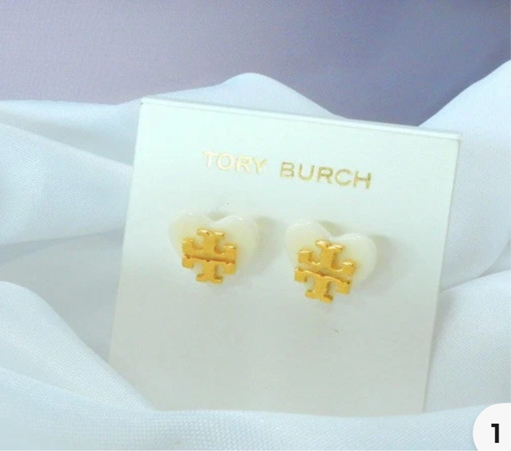 Aretes marca Tory Burch sobre corazón blanco