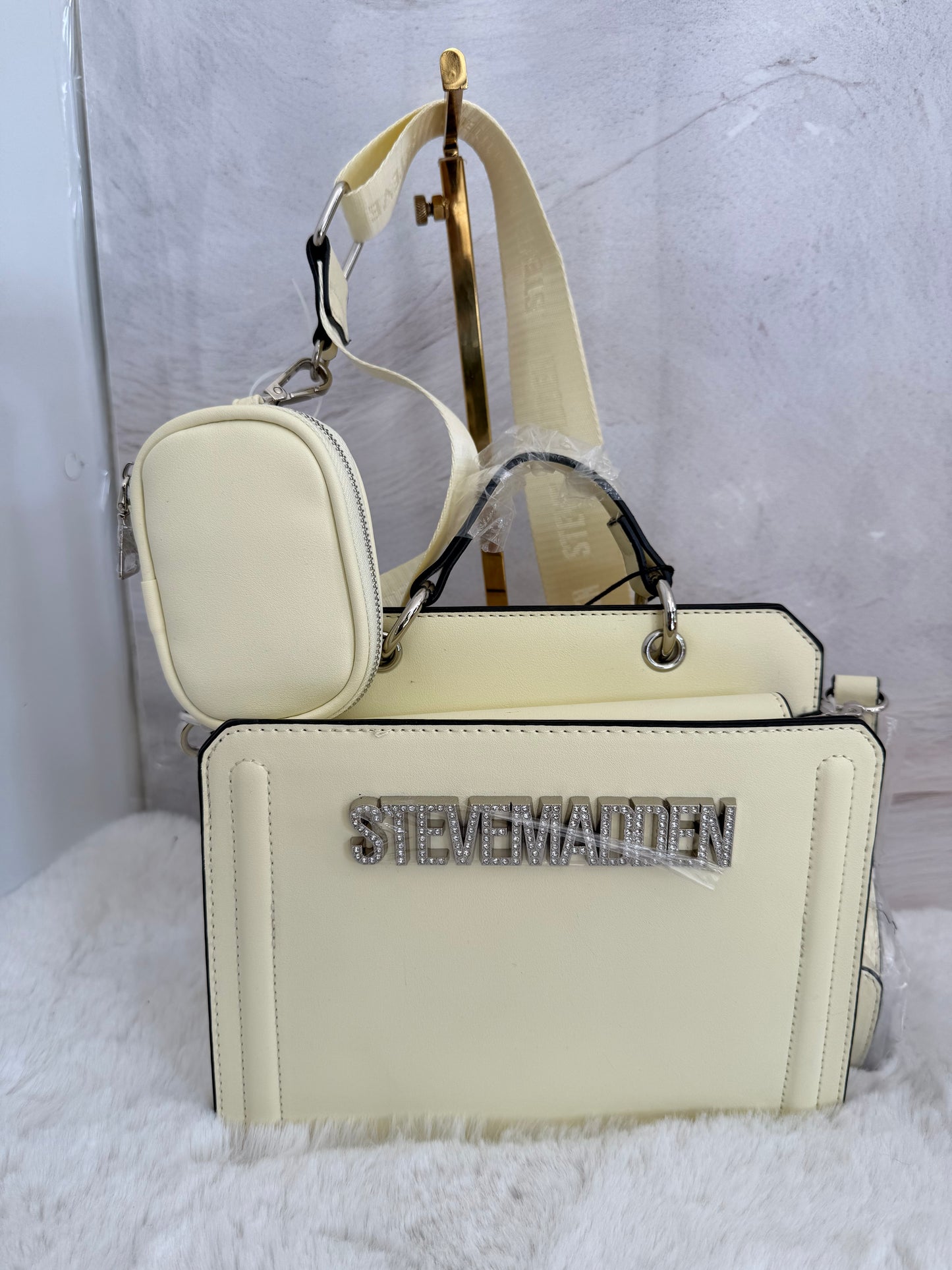 Bolsa chica con letras en piedras marca Steve madden